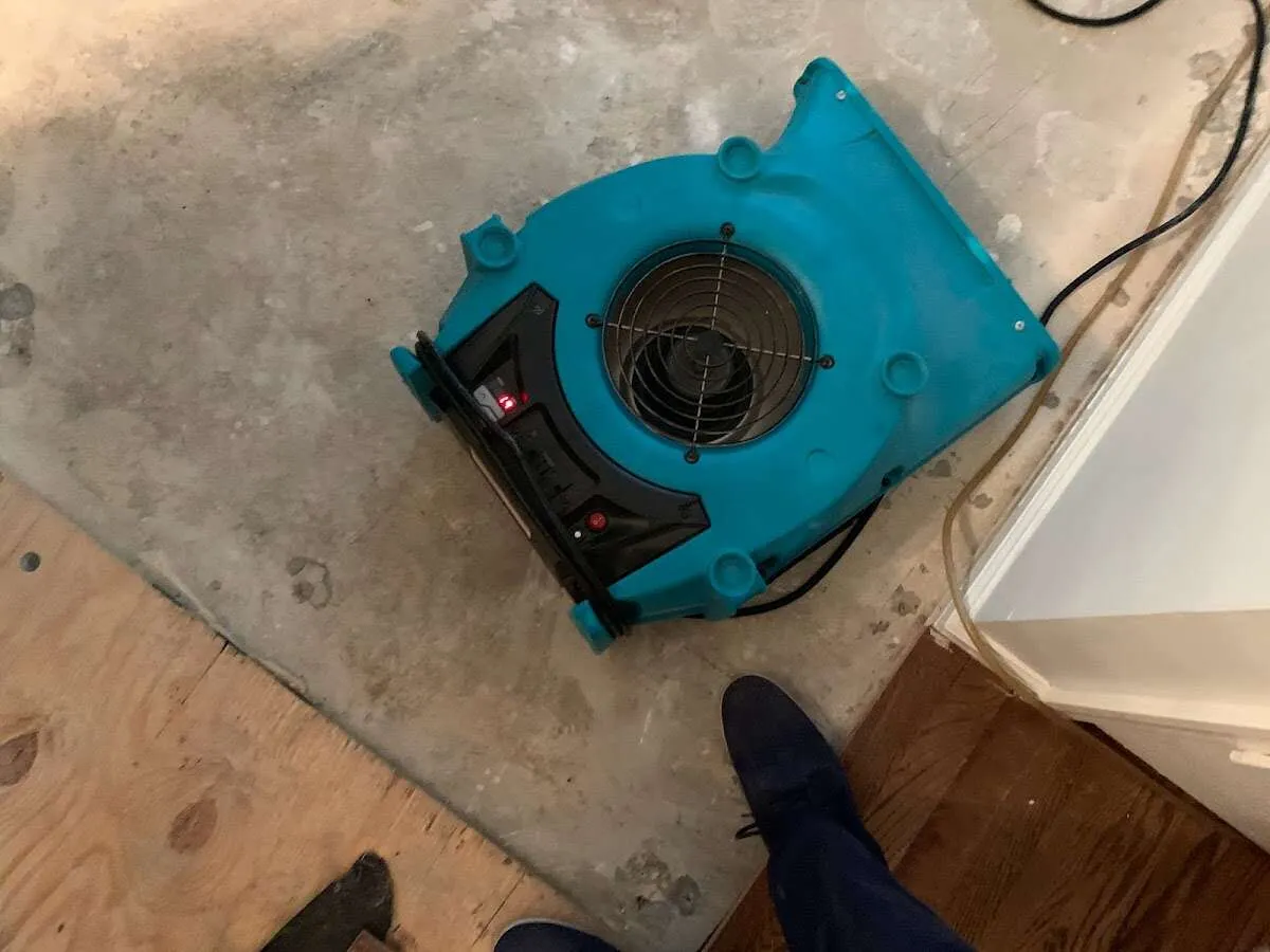 Air mover drying subfloor during Leak Detection & Repair in Fond du Lac